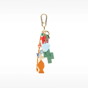 Detail of bohemian bag charm with colorful woven fish, heart pendant and vibrant beads