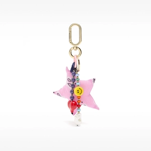 Detail of elegant handbag charm with pink star, smiley beads, heart and pearl pendant