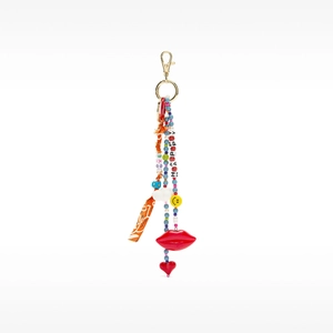 Close-up of colorful boho bag charm with Love and Happy beaded strands on a white background