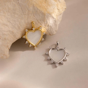 Detalle de colgantes de corazón en oro y plata con opale blanco y pequeños cristales