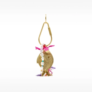 Detail of a vintage golden fish charm with colorful beads, pearls, and ethnic fabric tassels