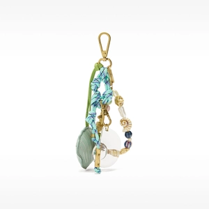 Detailed macro view of marine themed bag charm with shell pendants and woven cord