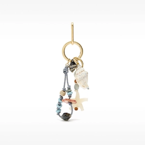 Detail of ocean-style bag charm featuring white conch, starfish, and blue beaded accents