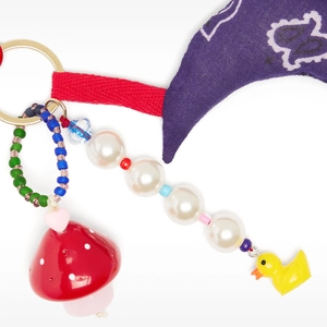 Detail of colorful charm keychain featuring red mushroom and cute duck pendants