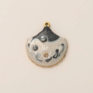 Macro-opname van de gouden schelphanger met emaille wervelpatroon en kleine parels