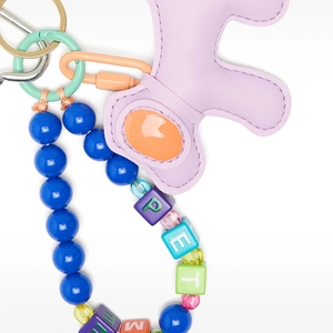 Detail of a purple leather bear charm with colorful PETME beads and blue bead chain