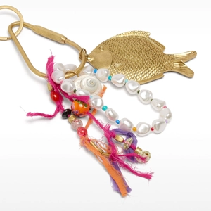 Detail of bohemian bag charm with golden fish pendant, baroque pearls, and colorful tassels