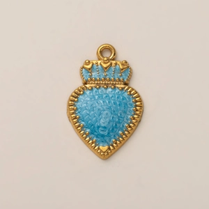 Dettaglio del ciondolo a cuore con corona placcato oro 18K con smalto blu e texture