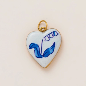 Close-up of heart-shaped 18K gold-plated pendant with blue lily flower enamel detail