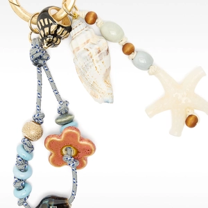 Detail of nautical bag charm with natural conch, starfish, and pink ceramic flower