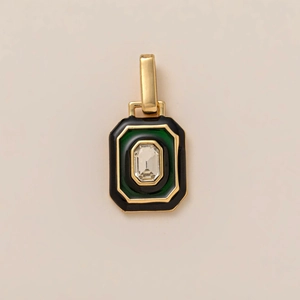 Macro view of emerald-cut crystal pendant with green enamel inlay and 18K gold frame