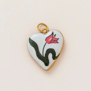 Detail of 18K gold-plated heart pendant with white enamel and pink tulip floral design