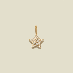 Détail macro du pendentif étoile en or avec pierres de zircone sur fond beige neutre