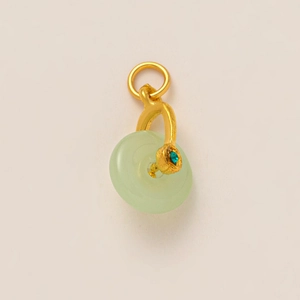 Vue macro du pendentif beignet en jade vert clair avec bélière dorée et gemme turquoise