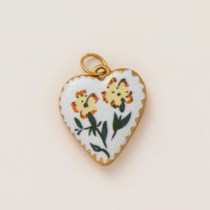 Detailed macro view of heart pendant with 18K gold plating and yellow flowers