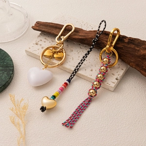 Vue détaillée de porte-clés tressés faits main avec perles colorées, cœurs et pompons