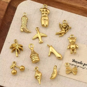 Collection of 12 gold plated stainless steel DIY charms including boot, angel, and cherry