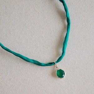 Grüner Edelsteinanhänger mit Silberfassung an Petrolkordel, minimalistischer Schmuck
