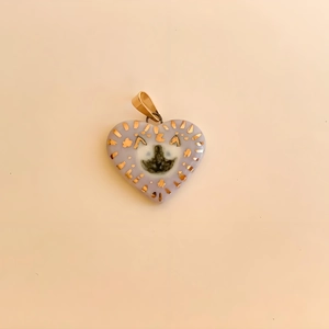 Detail of 18K gold-plated lavender heart pendant with a black cat motif and gold stars