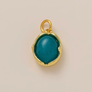 Détail du pendentif bohème doré avec pierre turquoise ovale et texture organique