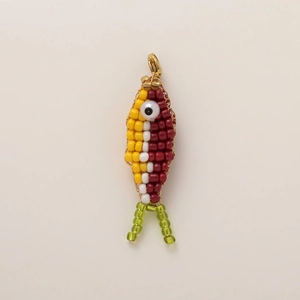 Détail d'un pendentif poisson fait main avec perles colorées et fermoir doré en homard