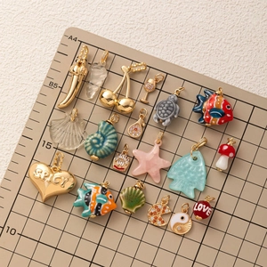 Assortimento di ciondoli placcati in oro con icone in smalto colorato e cuori incisi spicy