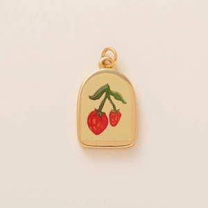 Dettaglio di un ciondolo a fragola ad arco con placcatura in oro e motivo floreale rosso