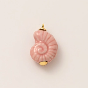 Dettaglio di un ciondolo a conchiglia rosa con cappucci dorati e anello per appenderlo