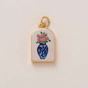 Detailed macro view of vintage heart pendant featuring pink roses and blue vase