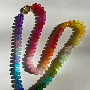 Macro view of rainbow faceted beaded necklace with golden ring clasp and sharp shadows