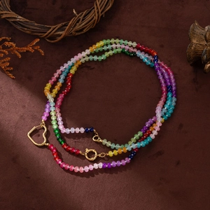 Colorful beaded multilayer necklace with gold heart clasp on rustic vintage background