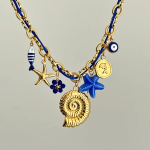Gros plan détaillé du pendentif coquille dorée et étoile de mer bleue sur le collier
