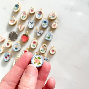Ciondolo in ceramica floreale fatto a mano con bordo dorato e motivo a fiori di pesco