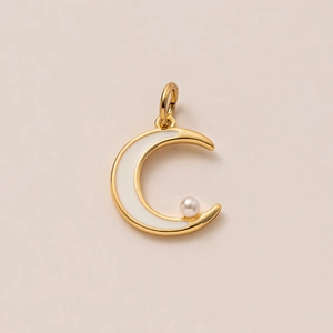 Détail d'un pendentif lune en or 18K avec émail blanc et une petite perle délicate
