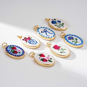 Set mit sieben 18K vergoldeten ovalen Anhängern mit Blumen- und Schleifen-Emaille-Mustern