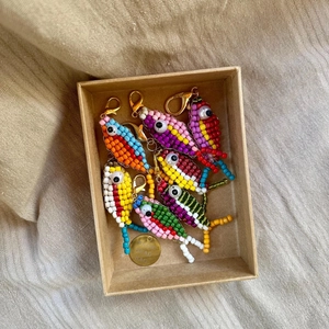 Gros plan de porte-clés poissons en perles colorées dans une boîte cadeau kraft