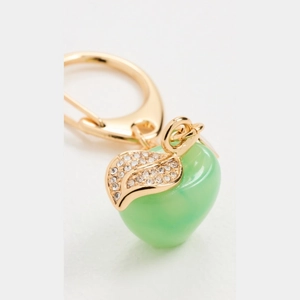 Macro shot of a translucent green apple pendant with a gold rhinestone leaf and clasp