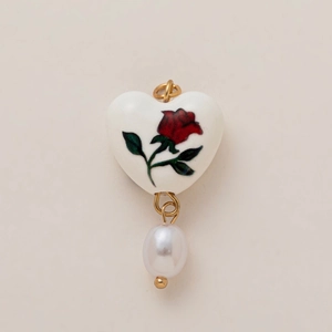 Detail of heart ceramic pendant with red rose pattern and white pearl drop element