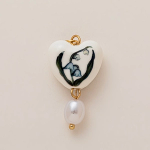 Detail of heart enamel pendant with lily of the valley pattern and baroque pearl