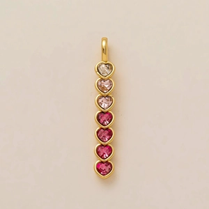 Détail d'un pendentif doré orné de sept pierres précieuses en forme de cœur