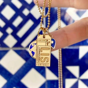 Detail of 18K gold Lisbon boarding pass pendant and blue enamel earth charm on bead chain