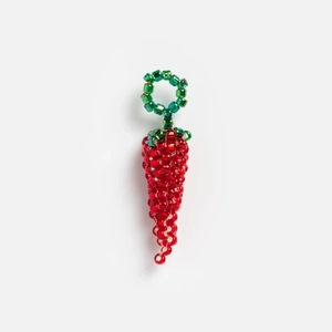 Detalle de un colgante de chile hecho a mano con cuentas rojas y hojas verdes decorativas