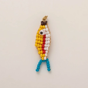 Close-up of handmade beaded fish charm with colorful beads and a gold lobster clasp