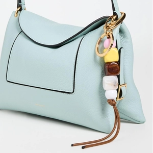 Detail of light blue leather handbag with acrylic beaded charm and Wandler logo
