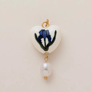 Detail of heart ceramic pendant with blue iris pattern and white teardrop pearl