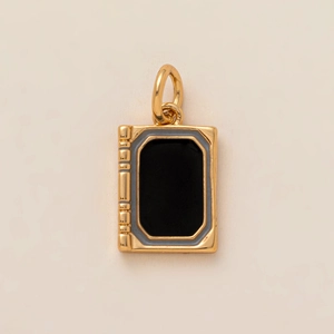 Vue détaillée d'un pendentif en forme de livre doré avec insert en émail noir élégant