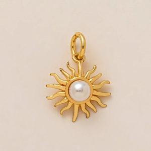 Vue détaillée d'un pendentif soleil doré avec perle centrale et bélière ronde
