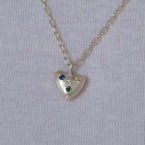 Detailaufnahme des Herzanhängers mit bunten Zirkoniasteinen an einer Edelstahlkette