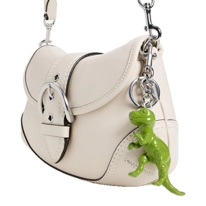 Off-white leather shoulder bag with large silver buckle and green dinosaur charm