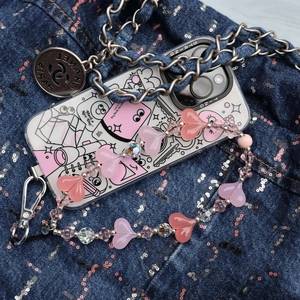 Cartoon phone case with pink heart beaded strap on blue denim background